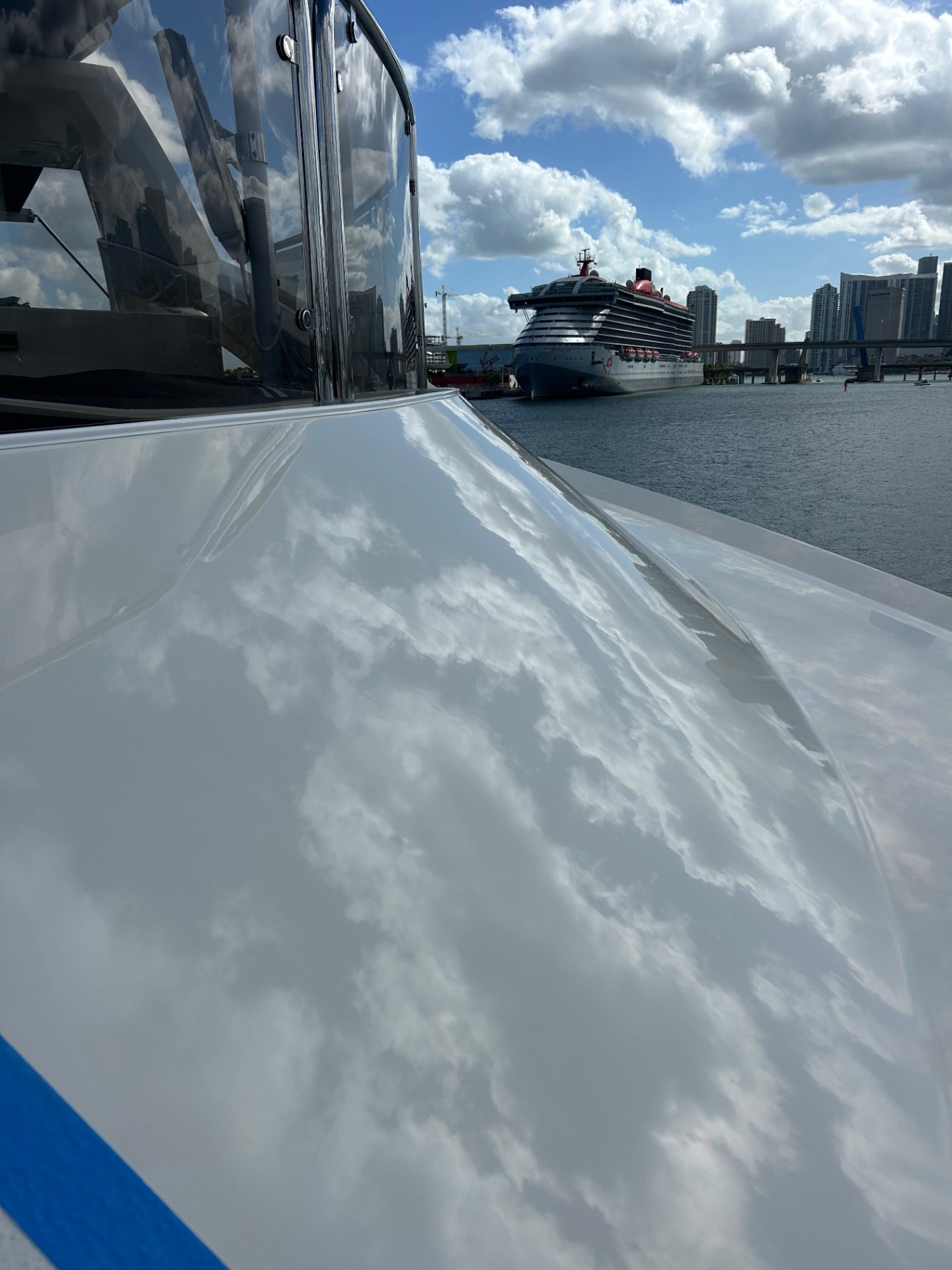 Sport yacht bow with mirror-finish gelcoat reflecting the Miami skyline